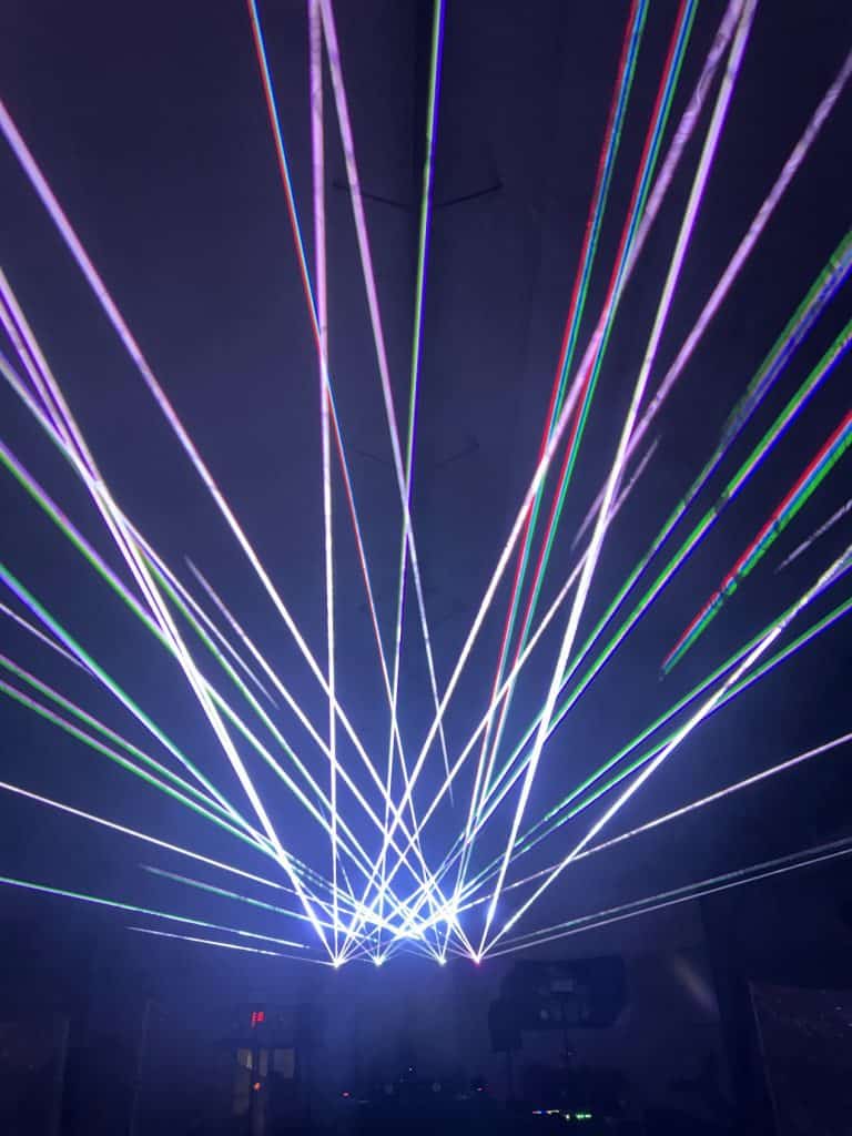 Laser light show with colorful beams in a dark venue, creating a vibrant and energetic atmosphere.
